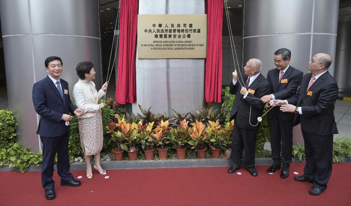 Regeringschefen Carrie Lam och Pekings representanter applåderar när Kinas nya agentkontor öppnar i det som nyligen var Metropark Hotel i Hongkong. Foto: Hongkongs regering/AP/TT