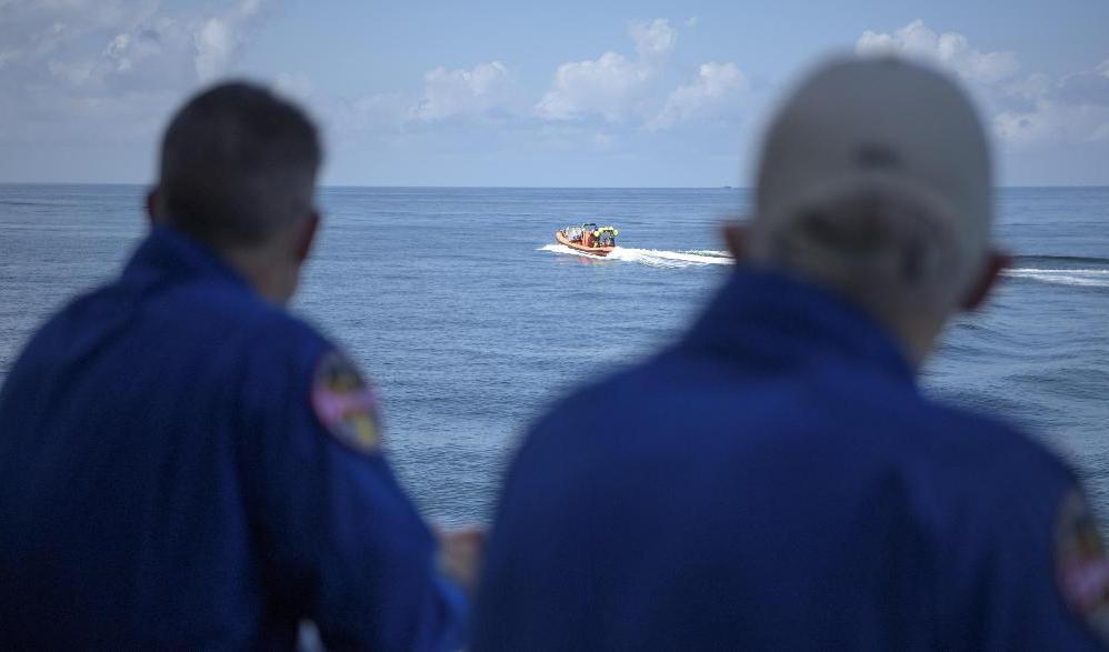 Motorbåtar skickades ut för att hämta astronauterna i havet. Foto: Bill Ingalls/NASA/AP/TT