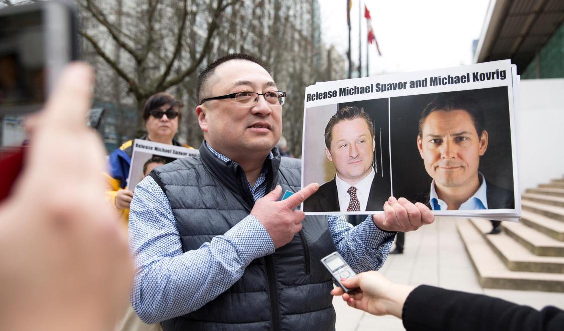 Louis Huang, Vancouver Freedom and Democracy for China, håller upp två foton på kanadensarna Michael Spavor och Michael Kovrig, utanför Vncouvers högsta domstol, den 6 mars 2019. Foto: Jason Redmond/AFP via Getty Images