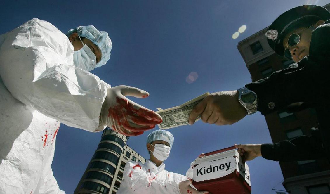 Kinesiska aktivister iscensätter hur det kan gå till i Kina då individer olagligt betalar för mänskliga organ under en demonstration. Den19 april 2006 i Washington, USA. Foto: Jim Watson/AFP/Getty Images