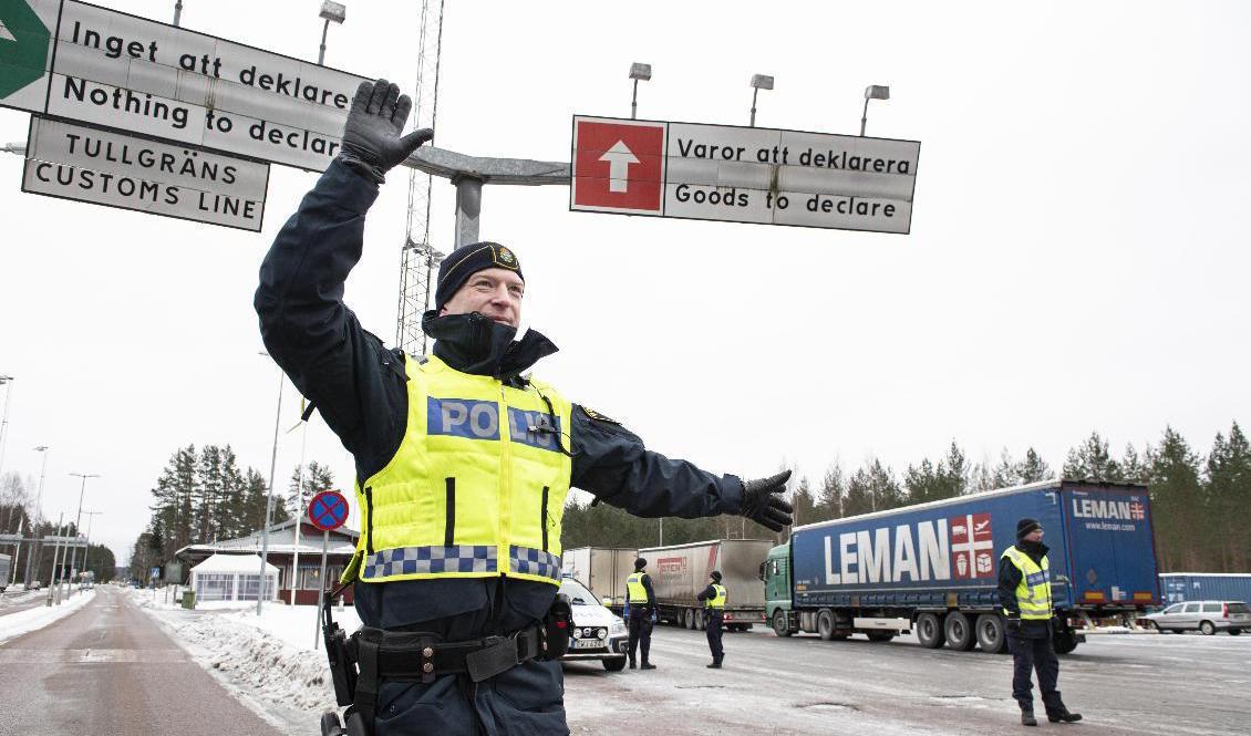 Andreas Berggren vinkar in bilarna som ska kontrolleras vid gränsen nära värmländska Charlottenberg. Foto: Tommy Pedersen/TT