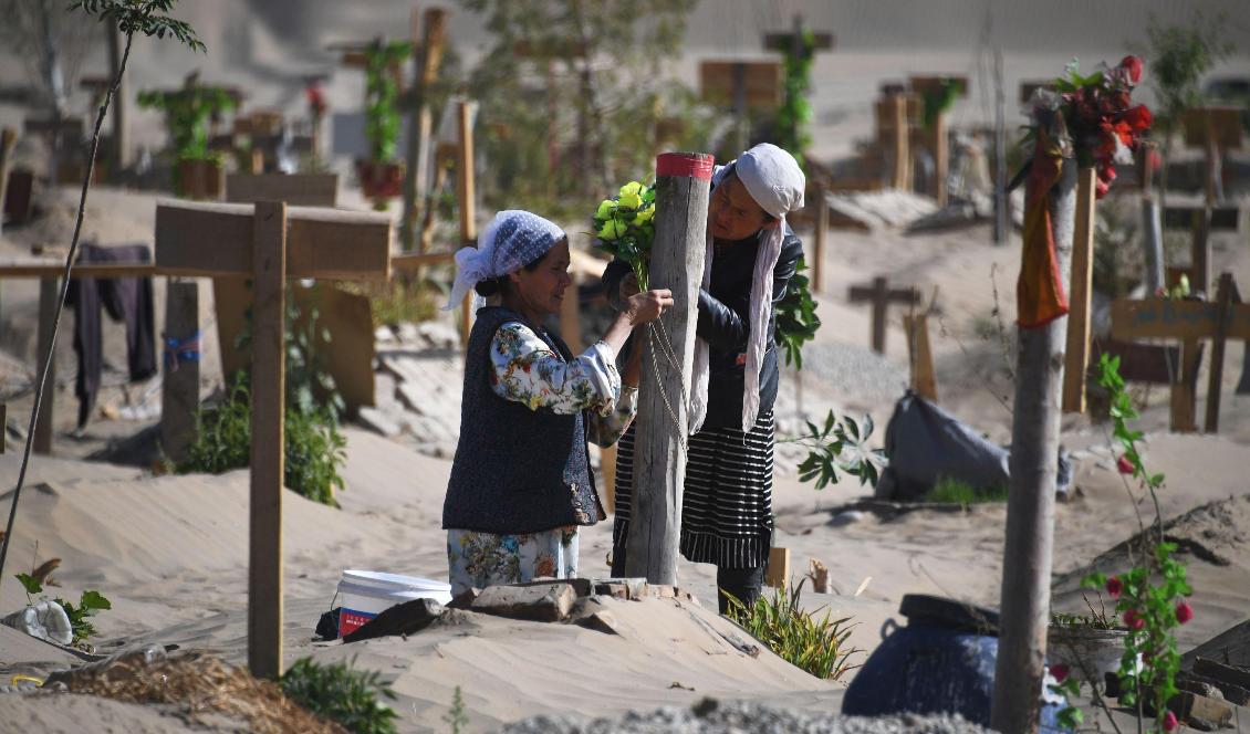 Två kvinnor vid en grav på en uigurisk kyrkogård i Hotan, Xinjiang, Kina, den 31 maj 2019. Foto: Greg Baker/AFP via Getty Images