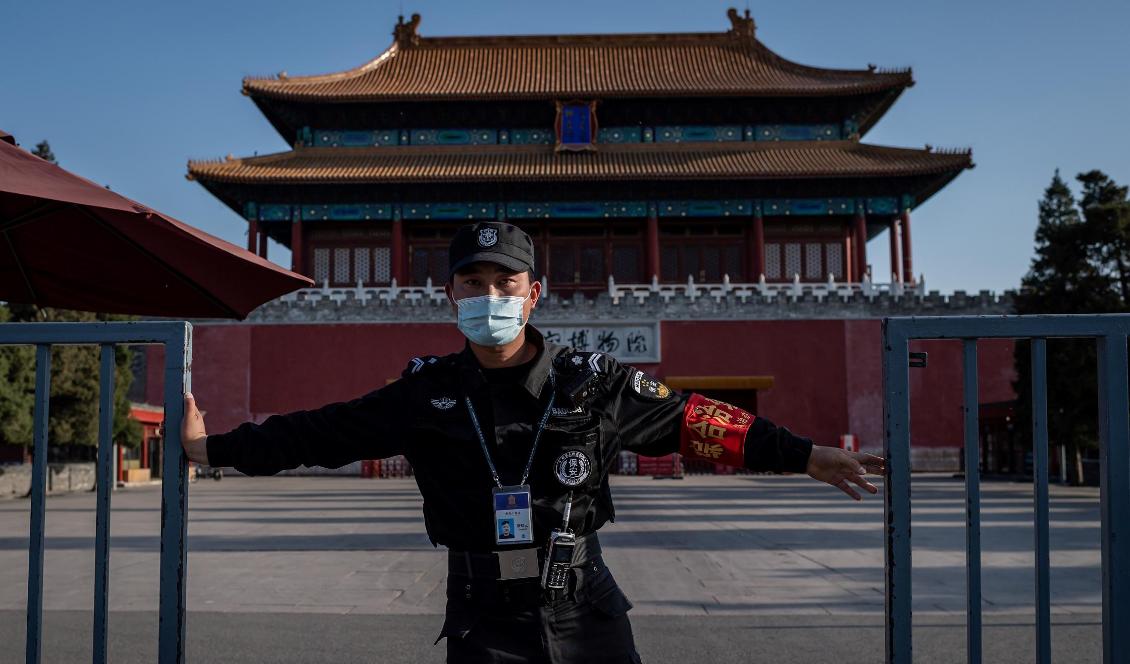 En säkerhetsvakt stänger en grind utanför den förbjudna staden i Peking i Kina den 12 april 2020. Foto: Nicolas Asfouri/AFP via Getty Images