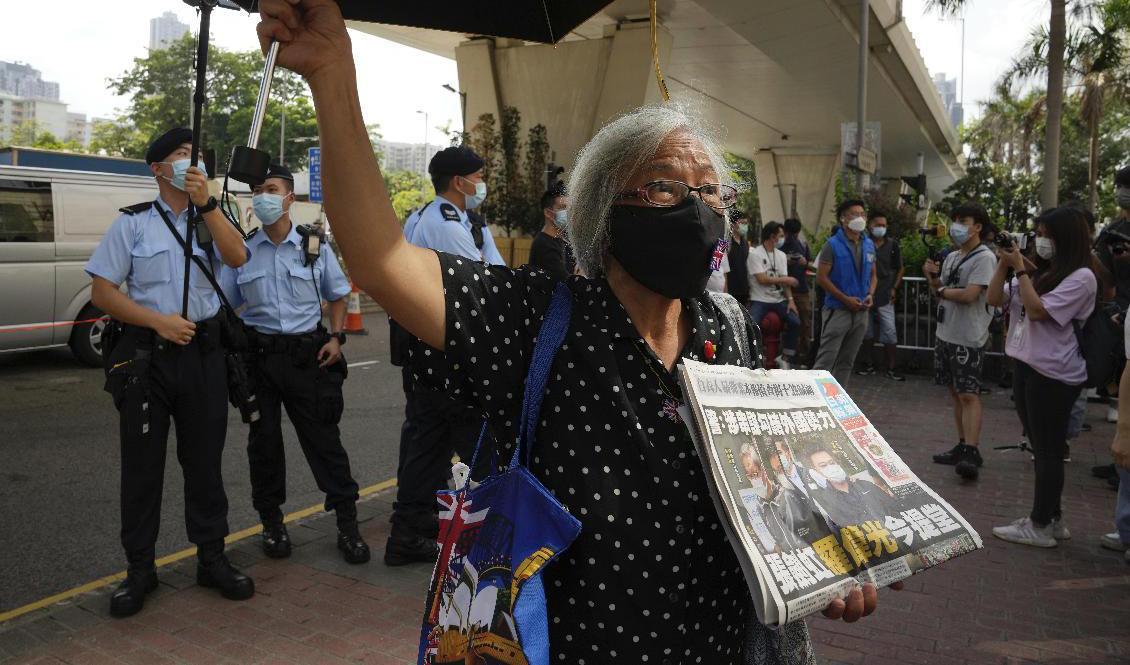 En demokratiaktivist med ett exemplar av Apple Daily utanför en domstol i Hongkong. Foto: Kin Cheung/AP/TT