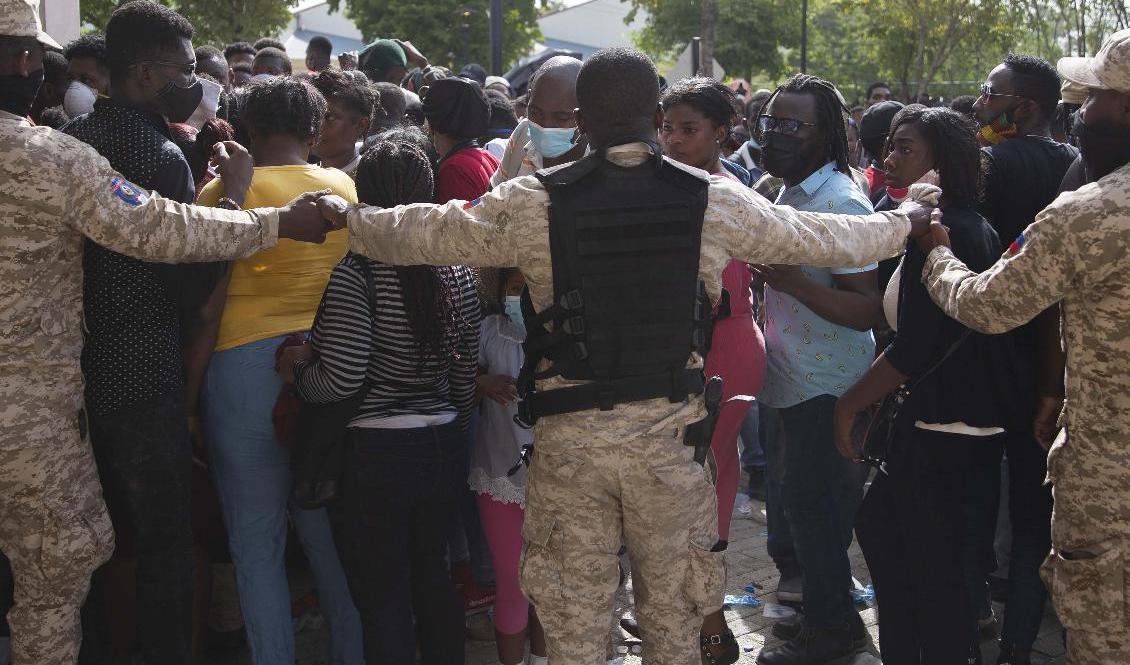 
Haitisk polis försöker hindra folk att ta sig till USA:s ambassad i huvudstaden Port-au-Prince på fredagen. Foto: Joseph Odelyn/AP/TT                                            