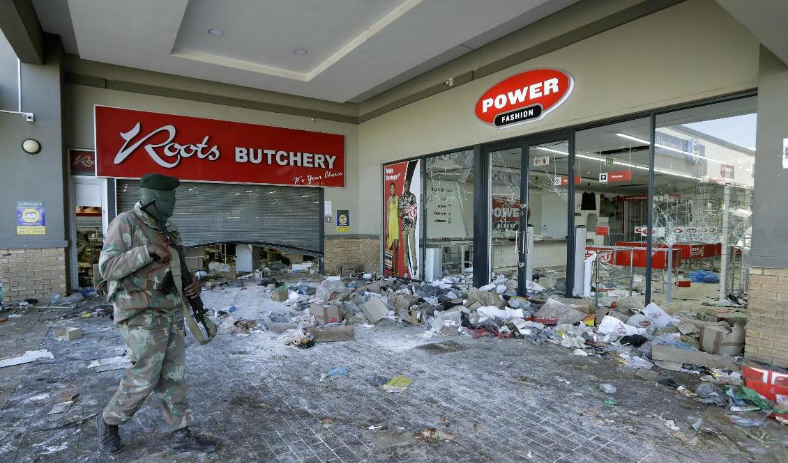 En soldat patrullerar vid ett plundrat köpcentrum i Soweto utanför Johannesburg. Foto: AP/TT