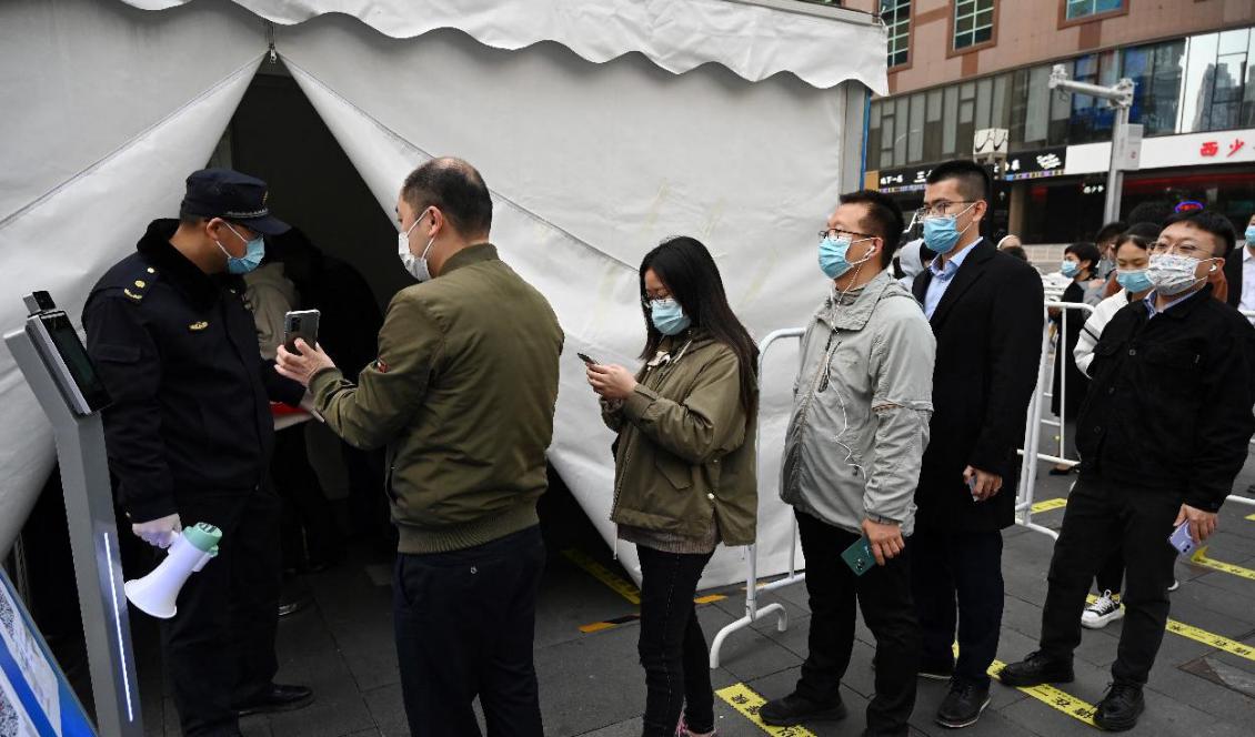 Folk står i kö för att få en tredje dos vaccin mot covid-19 i ett tält som ställts upp utanför ett köpcentrum i Peking den 1 november 2021. Foto: Greg Baker/AFP via Getty Images