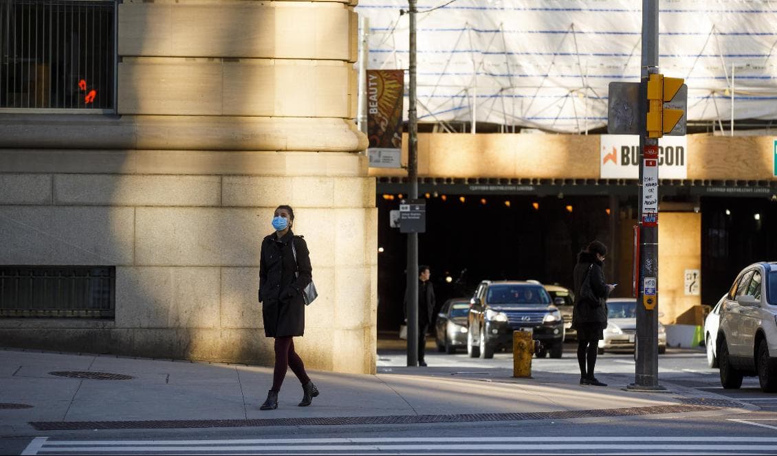 På bilden syns en kvinna bära mask i finansdistriktet i Toronto i Kanada den 1 april 2020. Foto: Cole Burston/Getty Images