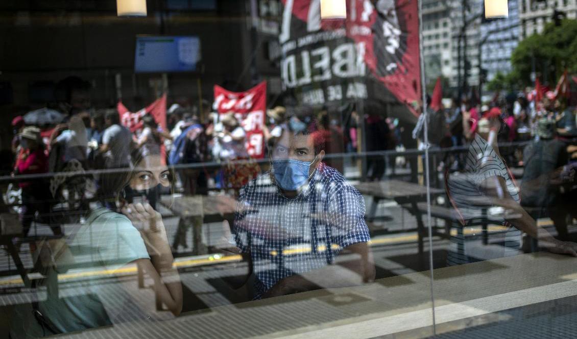 IMF-uppgörelserna är kontroversiella i Argentina. Här tittar ett par på en demonstration i Buenos Aires i januari. Foto: Rodrigo Abd/AP/TT