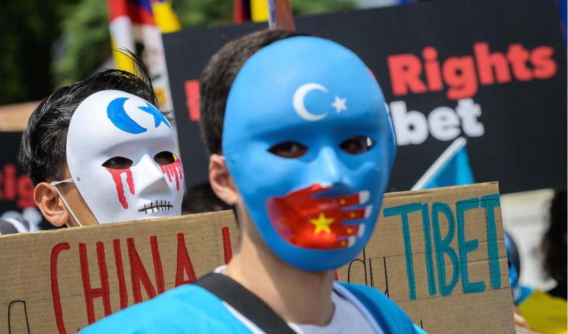 

Tibetanska och uiguriska aktivister bär masker under en protest mot vinter-OS i Peking 2022 framför Musée olympique i Lausanne den 23 juni 2021. Foto: Fabrice Coffrini/AFP via Getty Images                                                                                        
