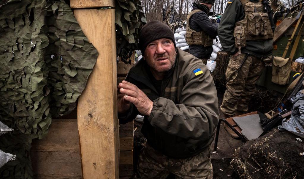 En ukrainsk militär tittar upp, han väntar i ett dike vid frontlinjen öster om Kharkiv den 31 mars 2022. Beskjutningen fortsätter i Kharkiv (norr) och Mariupol (söder). Foto: Fadel Senna/AFP via Getty Images