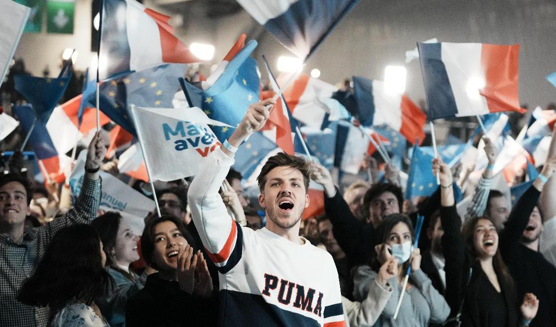 Stort jubel på president Emmanuel Macrons valvaka i Paris när resultaten från vallokalsundersökningarna presenterades i fransk tv. Foto: Thibault Camus/AP/TT