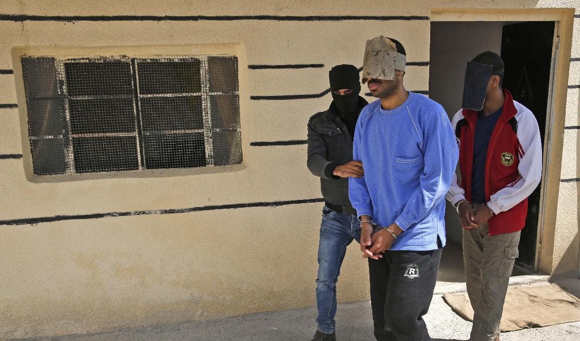 Alexanda Kotey (längst fram i blå tröja) och nu dömde El Shafee Elsheikh i ett fängelse i Syrien 2018. Arkivbild. Foto: Hussein Malla/AP/TT