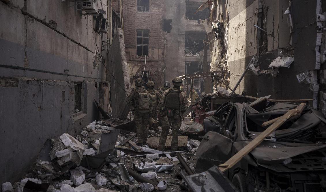 Ukrainska soldater rör sig genom bråten mellan husen efter att Ryssland på nytt attackerat Charkiv i nordöstra Ukraina på lördagen. Foto: Felipe Dana/AP/TT