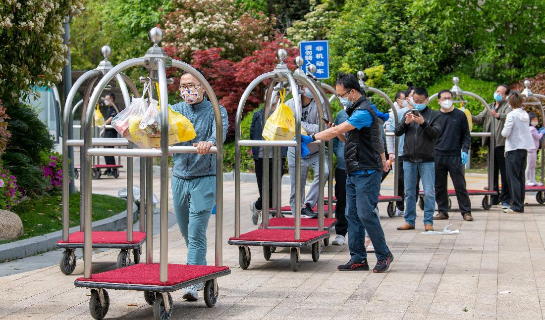 Lokala invånare står i kö för att hämta sin matleverans under covid-19-nedstängningen i Pudong-distriktet i Shanghai, Shanghai, den 15 april. Foto: Liu Jin/AFP via Getty Images