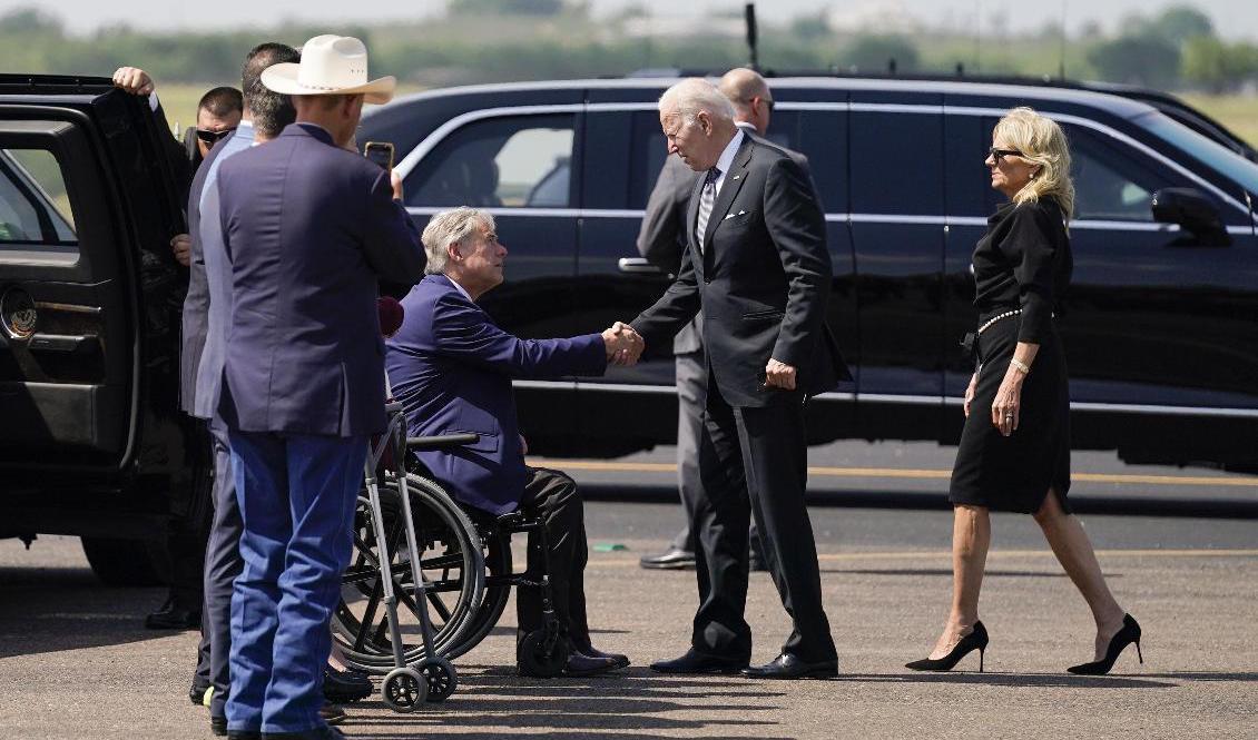 President Joe Biden och USA:s första dam Jill Biden anländer till Texas och hälsar på guvernör Greg Abbott (sittande till vänster). Foto: Evan Vucci/AP/TT