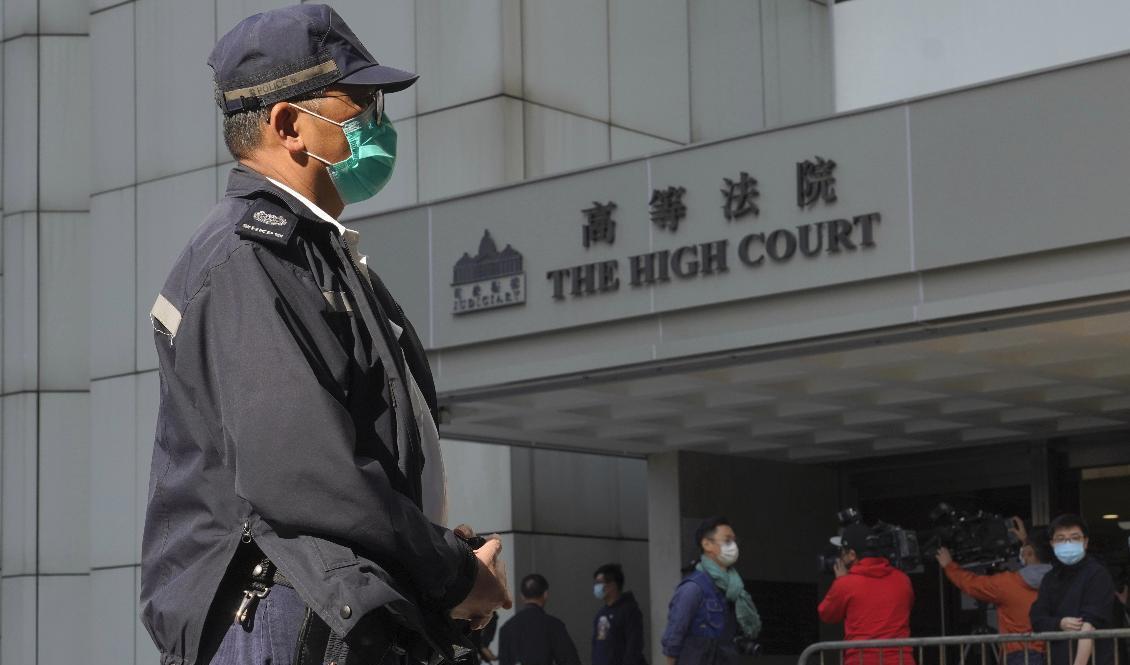 En polis står vakt utanför en domstol i Hongkong. 47 demokratiaktivister åtalas i den största rättegången hittills enligt linje med Kinas så kallade säkerhetslag. Arkivbild. Foto: Vincent Yu/AP/TT