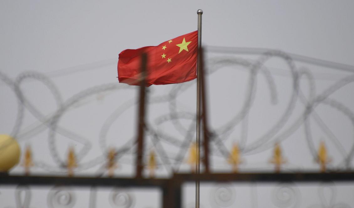 På bilden som är tagen den 4 juni 2019 syns en kinesisk flagga bakom taggtråd vid ett läger i Kashgar i Xinjiangregionen i Kina Foto: Greg Baker/AFP via Getty Images