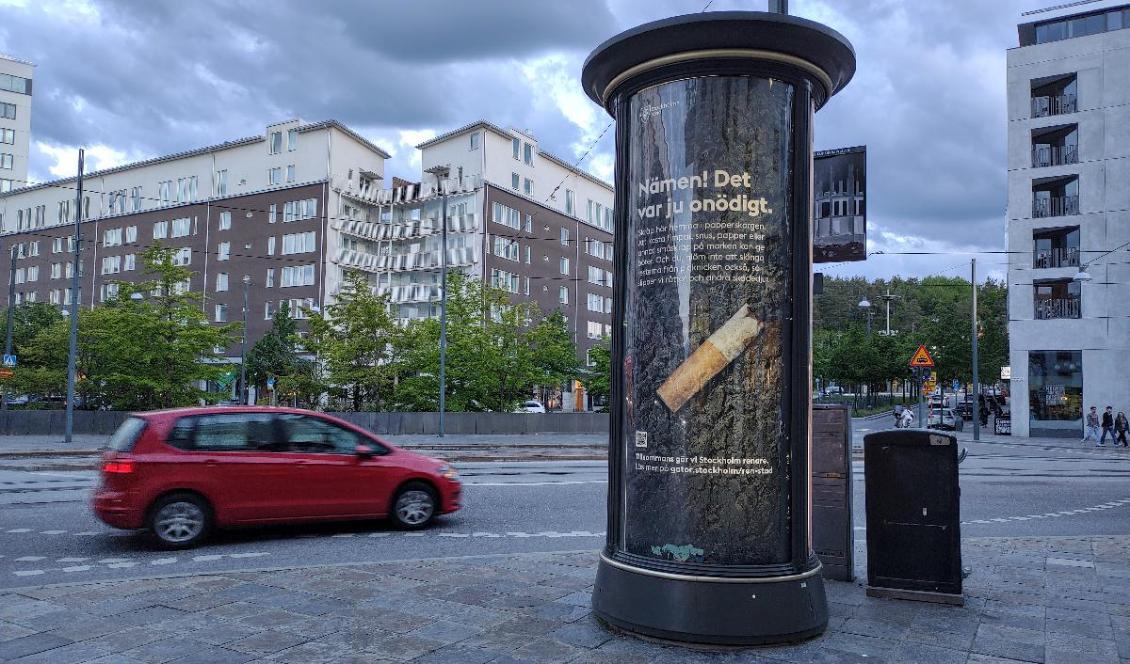 
Den förhatliga bilen passerar Stockholms stads reklam för att uppmuntra folk att inte förfula staden med fimpar. Foto: Emil Almberg                                            