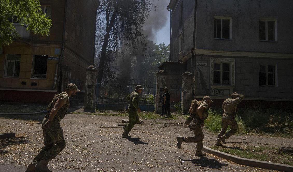 
Ukrainska soldater söker skydd efter ett attack mot ett bostadsområde i Kramatorsk i Donetsk. Foto: Nariman El-Mofty/AP/TT                                            