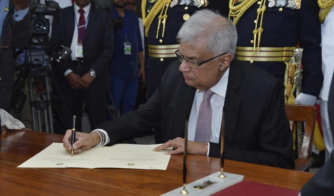 
Sri Lankas nya president Ranil Wickremesinghe undertecknar ett dokument efter att ha avlagt presidenteden på torsdagen. Foto: AP/TT                                            