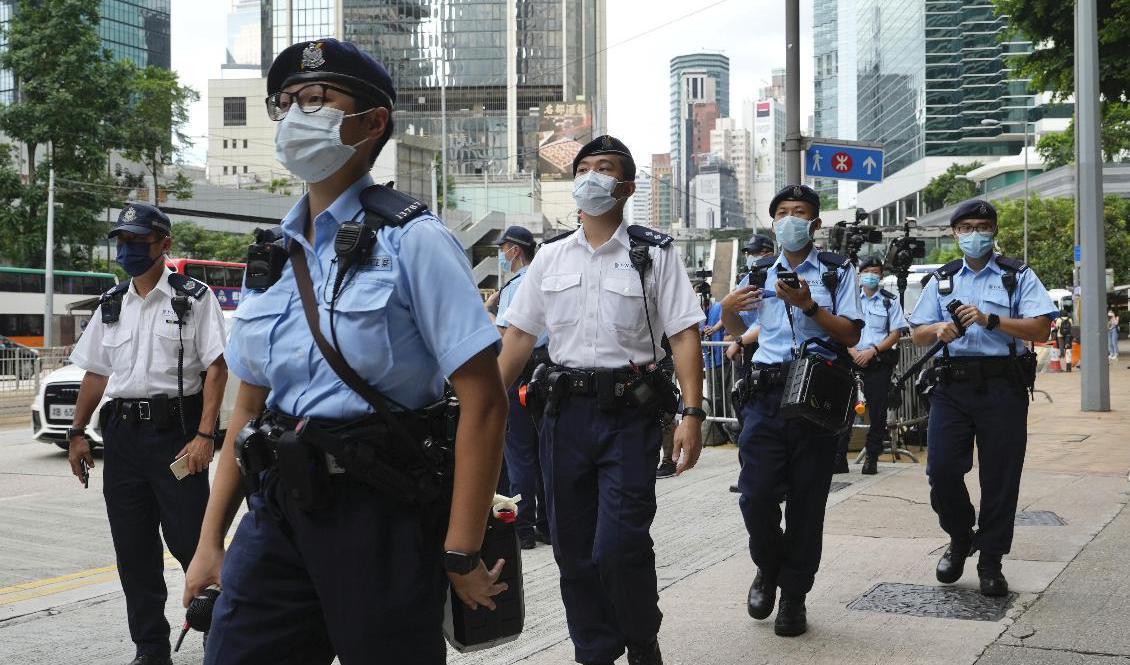 Poliser patrullerar i väntan på att aktivisten Tong Ying-kit ska lämna domstolen i Hongkong den 30 juli 2021, efter att ha dömts till nio års fängelse för att ha brutit mot den nationella säkerhetslagen. Foto: Vincent Yu/AP/TT
