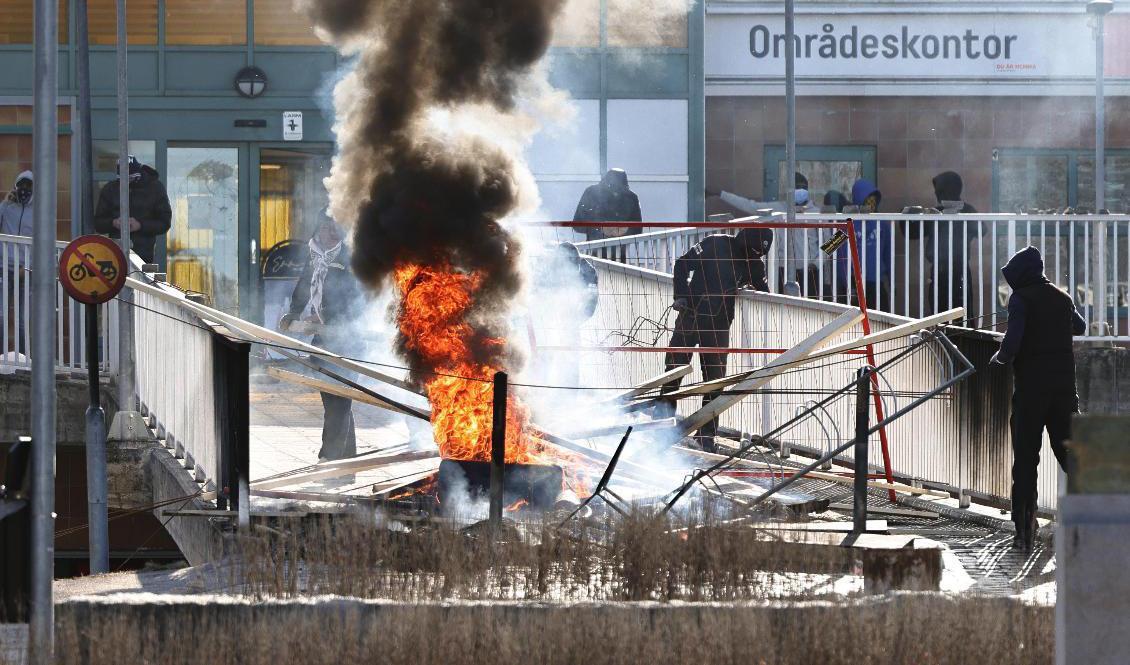 Personer gör en barrikad med brinnande bildäck och andra föremål i Norrköping på påskdagen, den 17 april 2022. Foto: Stefan Jerrevång/TT