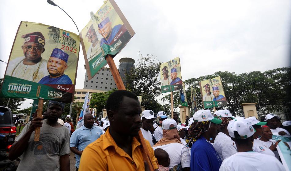 Anhängare av Nigerias styrande parti APC håller upp affischer med partiets kandidater i presidentvalet vid ett möte möte i Abuja den 20 juli 2022. Foto: Kola Sulaimon/AFP via Getty Images