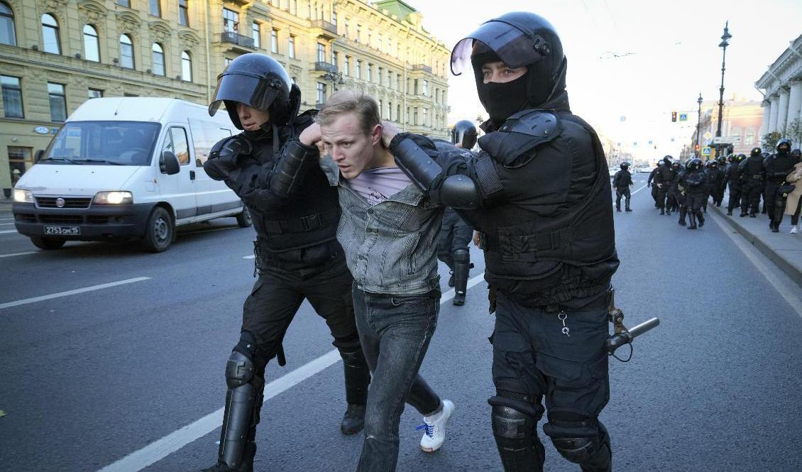Ryska kravallpoliser för iväg en demonstrant i S:t Petersburg på lördagen. Foto: AP/TT