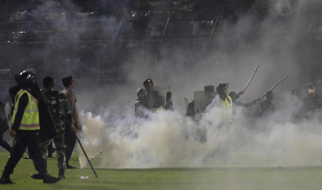 

När hemmasupportrarna stormade planen svarade polisen med att skjuta tårgas. Foto: Yudha Prabowo/AP/TT                                                                                        