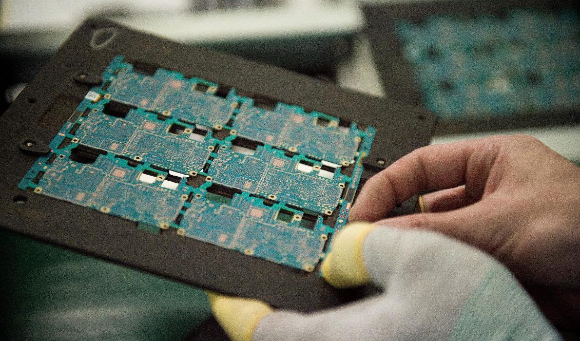 Kretsar med chipkomponenter till smarta telefoner hanteras på fabriken Oppo i kinesiska Dongguan, den 8 maj 2017. Foto: Nicolas Asfouri/AFP via Getty Images