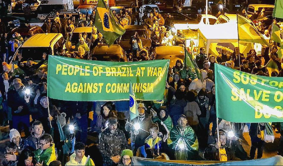 Demonstranter med banderoll på engelska med texten ”Brasiliens folk i krig mot kommunismen” i staden Curitiba, Brasilien, den 4 november 2022. Foto: Frederico Vidovix