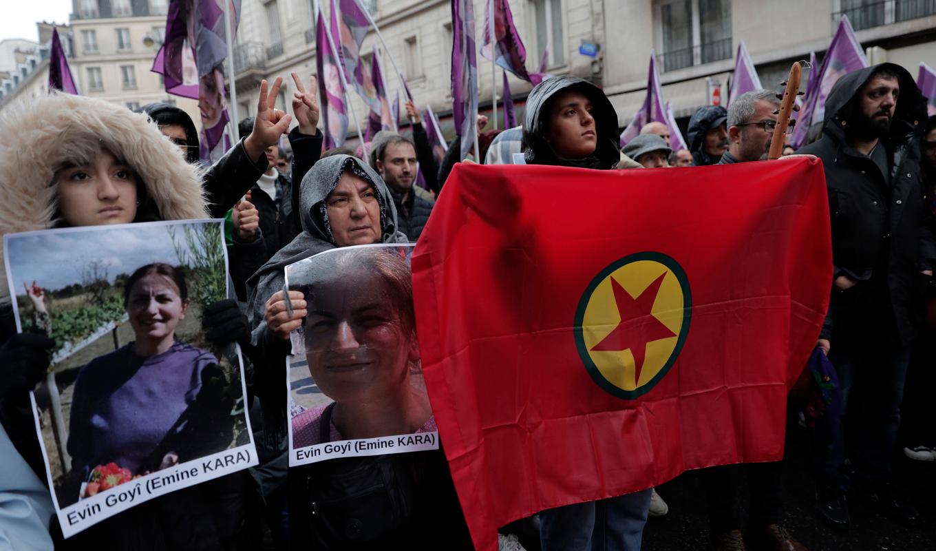 Demonstranter i Paris håller upp en PKK-flagga och porträtt över offren för dödsskjutningarna i fredags. Foto: Lewis Joly/AP/TT