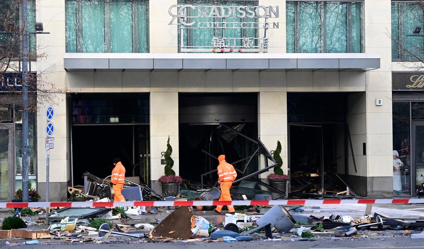 Glas och annat bråte sveptes ut på gatan framför hotellet Radisson Blu i Berlin i Tyskland den 16 december 2022 i samband med att ett gigantiskt akvarium exploderade. Foto: John MacDougall/AFP via Getty Images