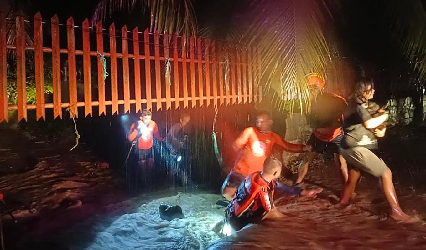 
Bilden som tillhandahållits av filippinska kustbevakningen visar människor som flyr från ett översvämmat område i staden Ozamiz i Filippinerna. Foto: Filippinernas kustbevakning/AFP/TT                                            