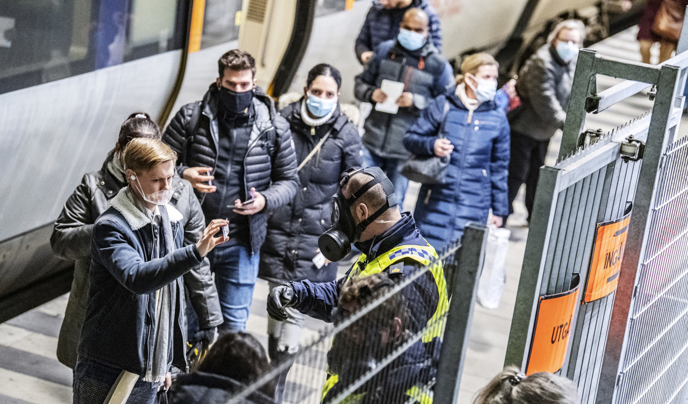Polis i skyddsmask kontrollerar resenärer som ankommit från Danmark med Öresundståg på perrongen på Hyllie station i Malmö. Arkivbild från december 2020. Foto: Johan Nilsson/TT