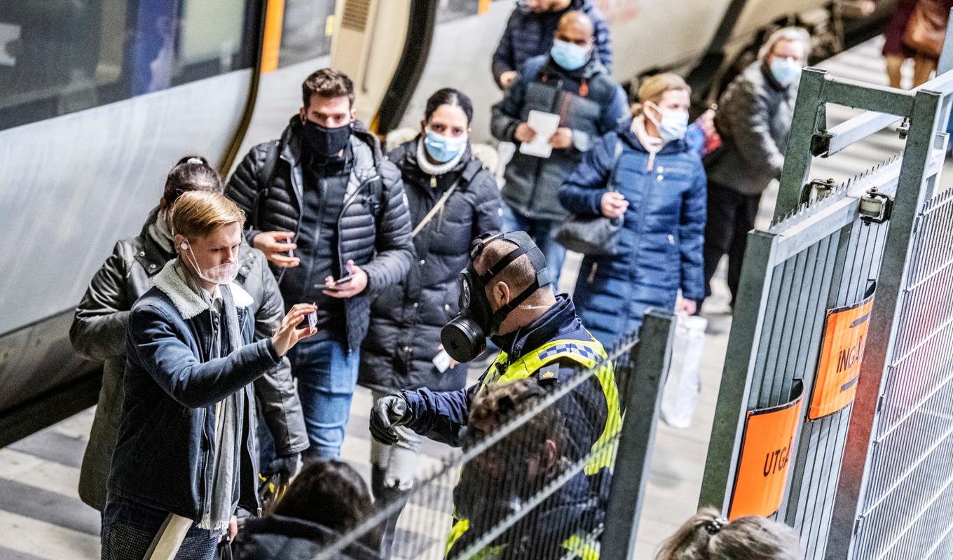 Polis i skyddsmask kontrollerar resenärer som ankommit från Danmark med Öresundståg på perrongen på Hyllie station i Malmö. Arkivbild från december 2020. Foto: Johan Nilsson/TT