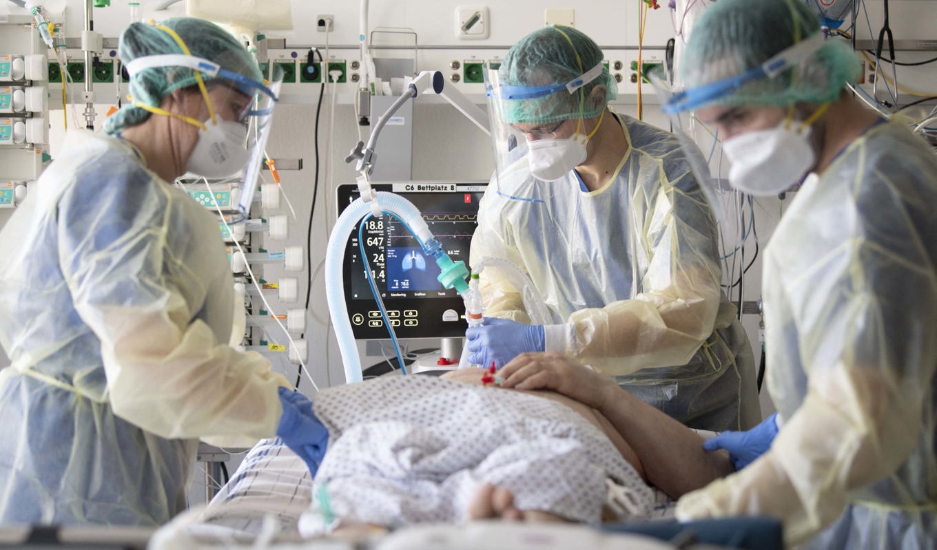 Vårdpersonal tar hand om en patient på covid-19-intensiven på ett tyskt sjukhus i mars 2021. Nu anser en tysk virolog att pandemin är över.Foto: Thomas Kienzle/AFP via Getty IMmages.