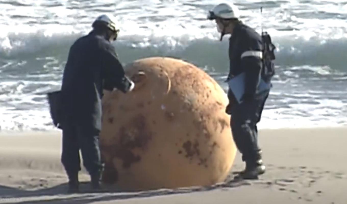 En hittills oidentifierad metallisk sfär har spolat upp på en strand i den japanska kuststaden Hamamatsu. Vissa har spekulerat om att det skulle röra sig om ett UFO eller en så kallad Dragon Ball. Foto: Skärmdump/NHK/Twitter