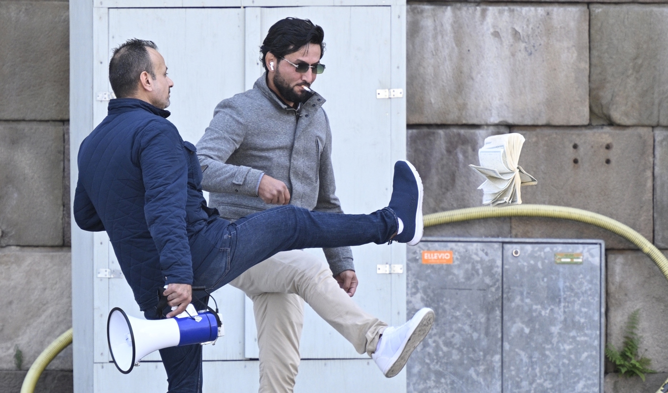 Salwan Momika och Salwan Najem sparkade först på boken innan Najem tände eld på några sidor. Foto: Anders Wiklund/TT