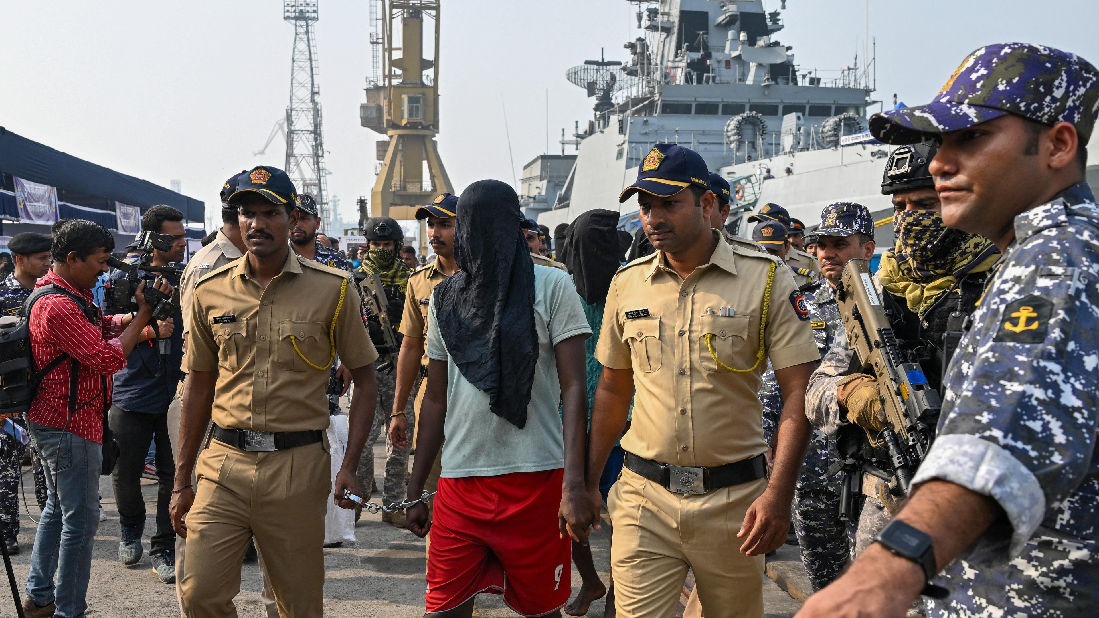 Poliser eskorterar en anklagad somalisk pirat till en polisbil vid det indiska fartygsvarvet i Bombay den 23 mars. Foto: Indranil Mukherjee/AFP via Getty Images
