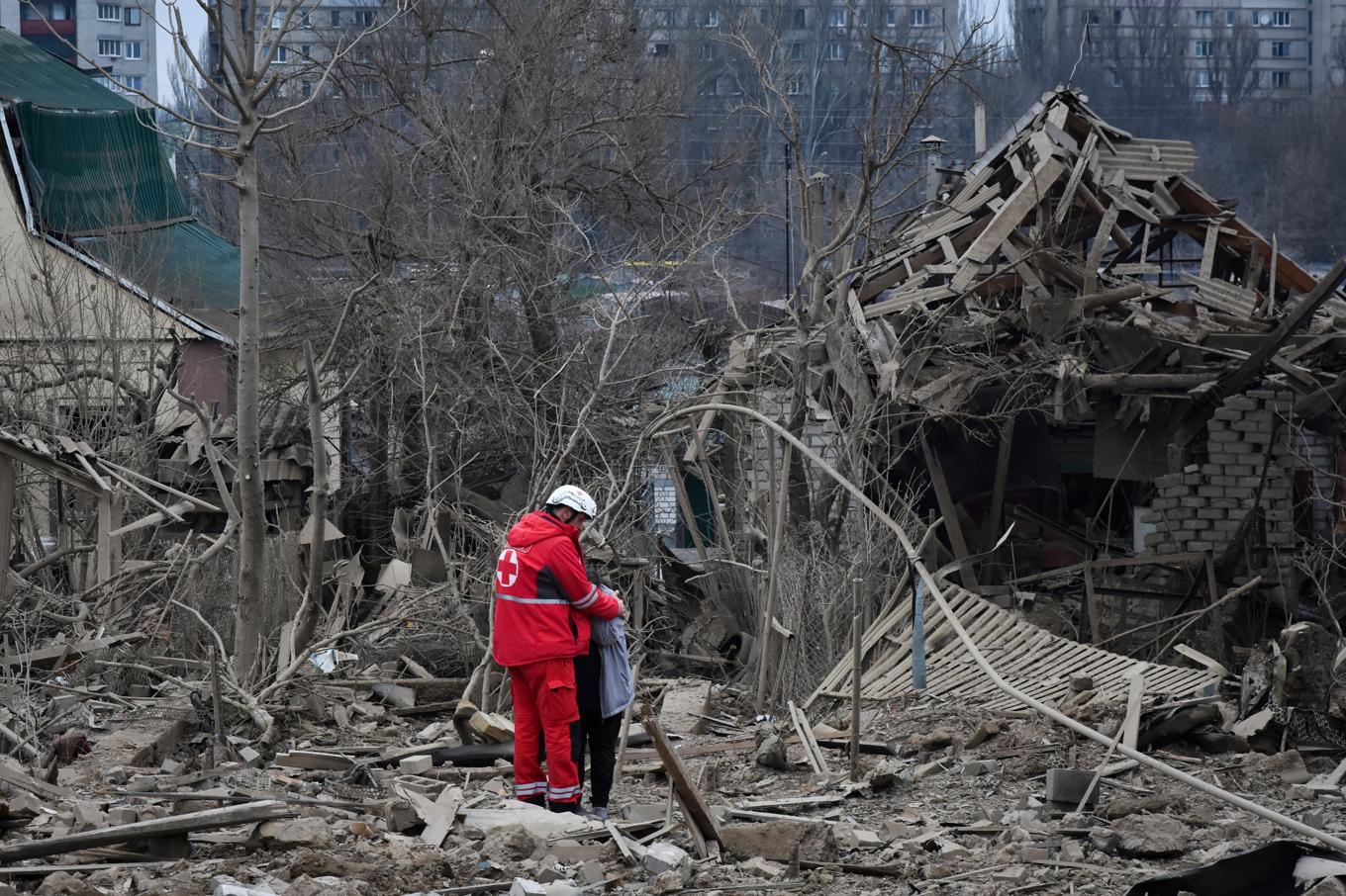 En räddningsarbetare tröstar en kvinna efter ett ryskt flyganfall som förstörde en länga bostadshus i Zaporizjzja-regionen i slutet av mars i år. Arkivbild. Foto: Andriy Andriyenko/AP/TT