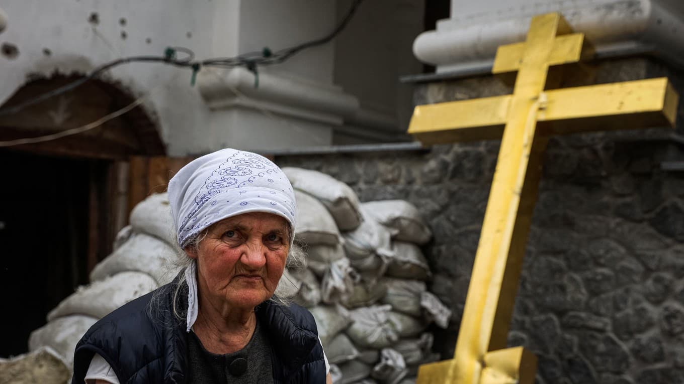 Tre olika patriarker gör anspråk på den Ortodoxa kyrkan i Ukraina. Bilden visar en kvinna vid en kyrka nära staden Sviatohirsk i Donetskregionen i Ukraina, den 30 september 2022. Foto: Anatolii Stepanov/AFP via Getty Images