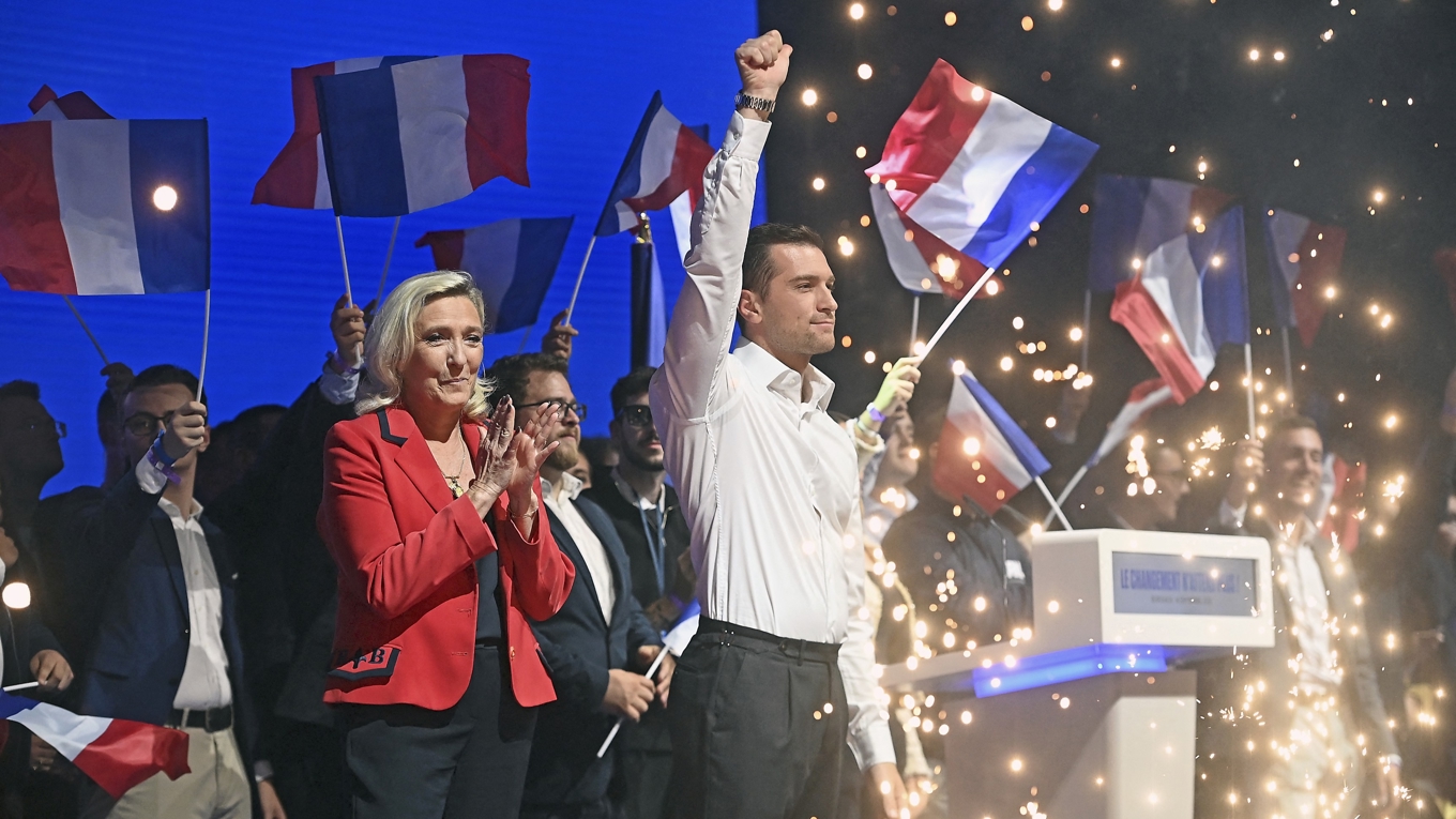 Franska RN:s ledare Jordan Bardella och företrädaren Marine Le Pen vid ett partievenemang. Foto: Christophe Archambault/AFP Getty Images