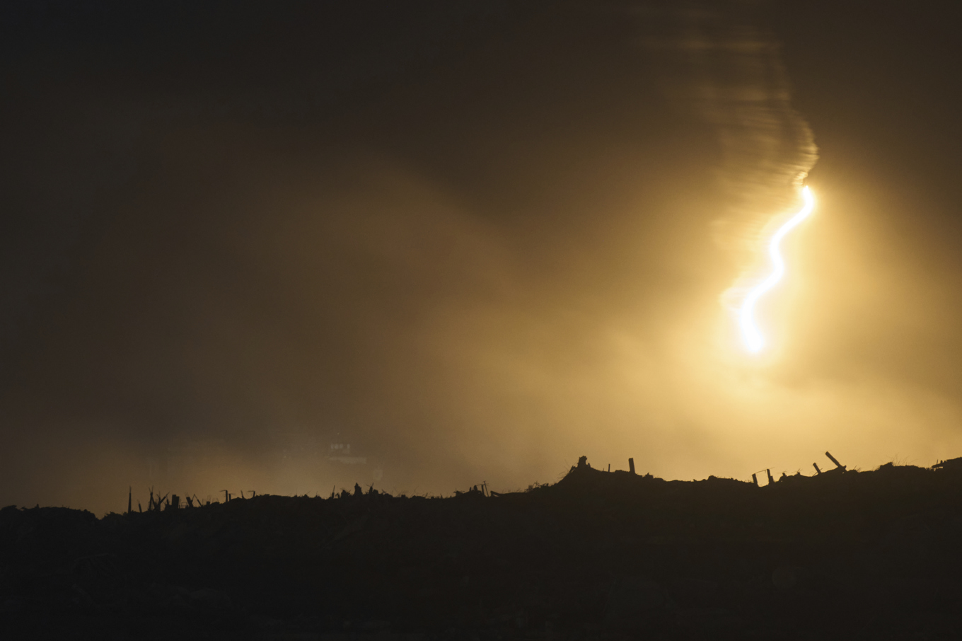 En militär israelisk fackla lyser upp norra Gazaremsan på tisdagskvällen. Foto: Leo Correa/AP/TT