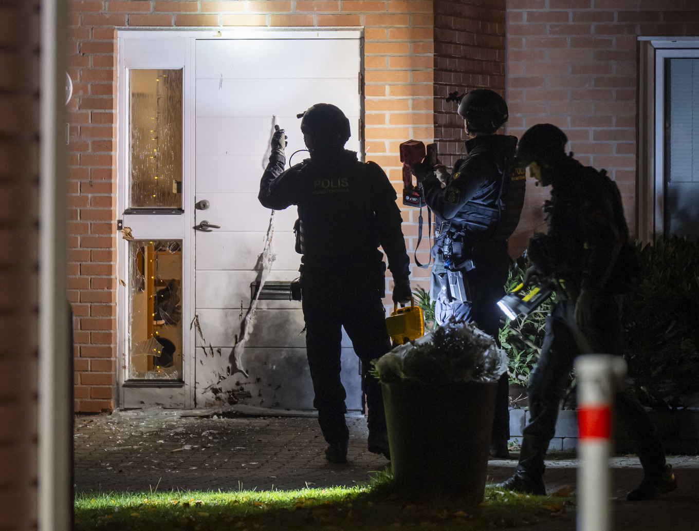 Polisens bombtekniker på plats vid entrén till en lägenhet i ett flerfamiljshus i Malmö. Foto: Johan Nilsson / TT