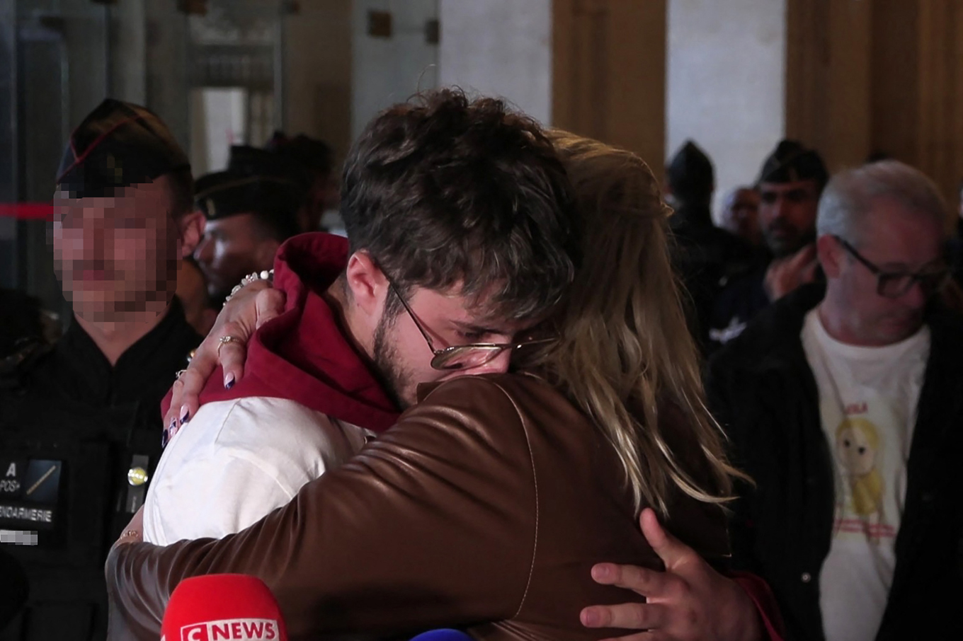 Mamman och brodern, Delphine Daviet och Thibault, till 12-åriga Lola, kramar om varandra utanför en domstol i Paris den 24 oktober. Foto: Sibille Arnaud Richard/AFPTV/AFP via Getty Images