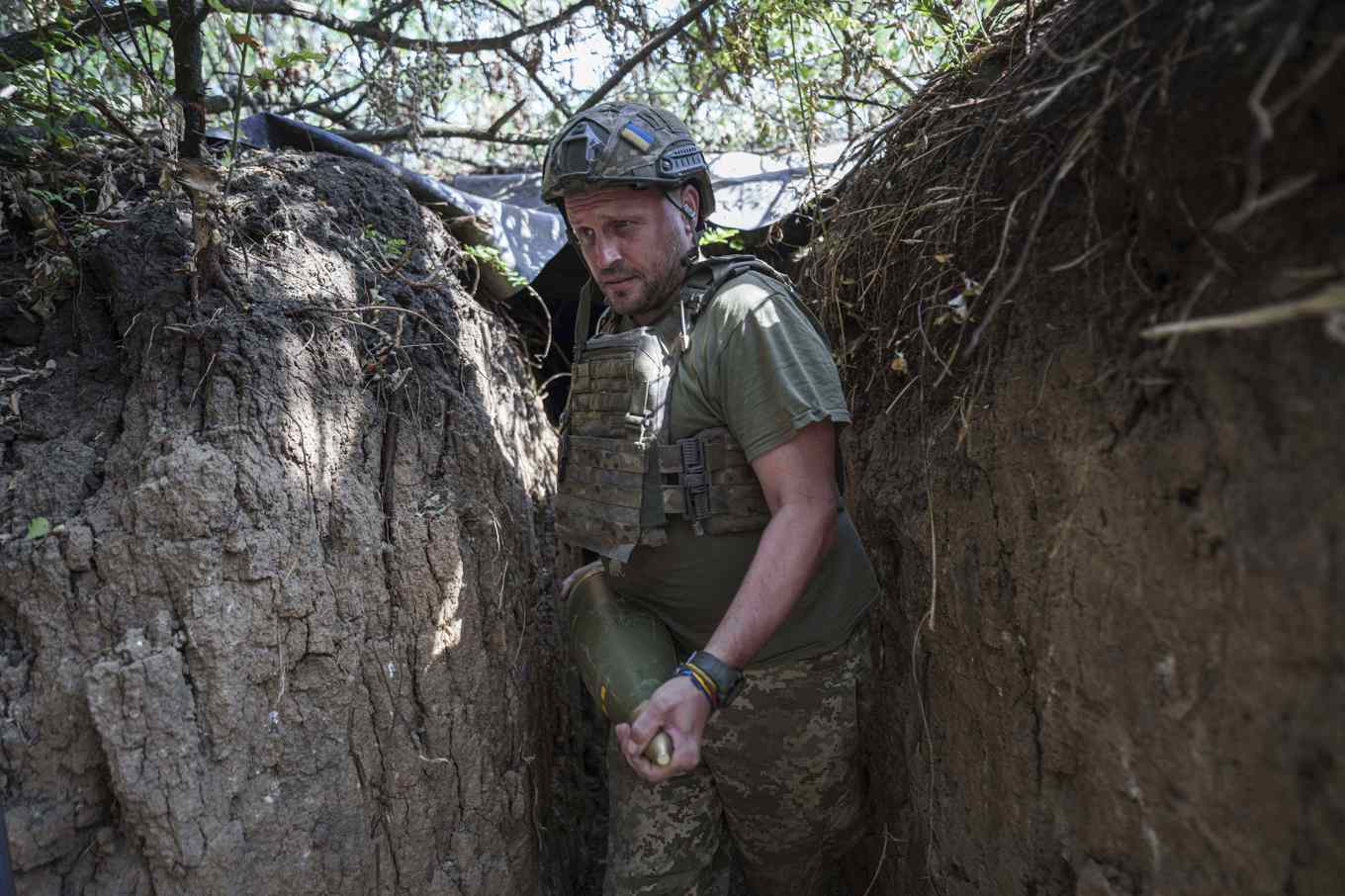En soldat i en ukrainsk artilleribrigad bär en granat som ska avfyras mot ryska styrkor vid fronten i Zaporizjzja-regionen i Ukraina. Bilden togs den 7 augusti i år. Foto: Evgeniy Maloletka/AP/TT