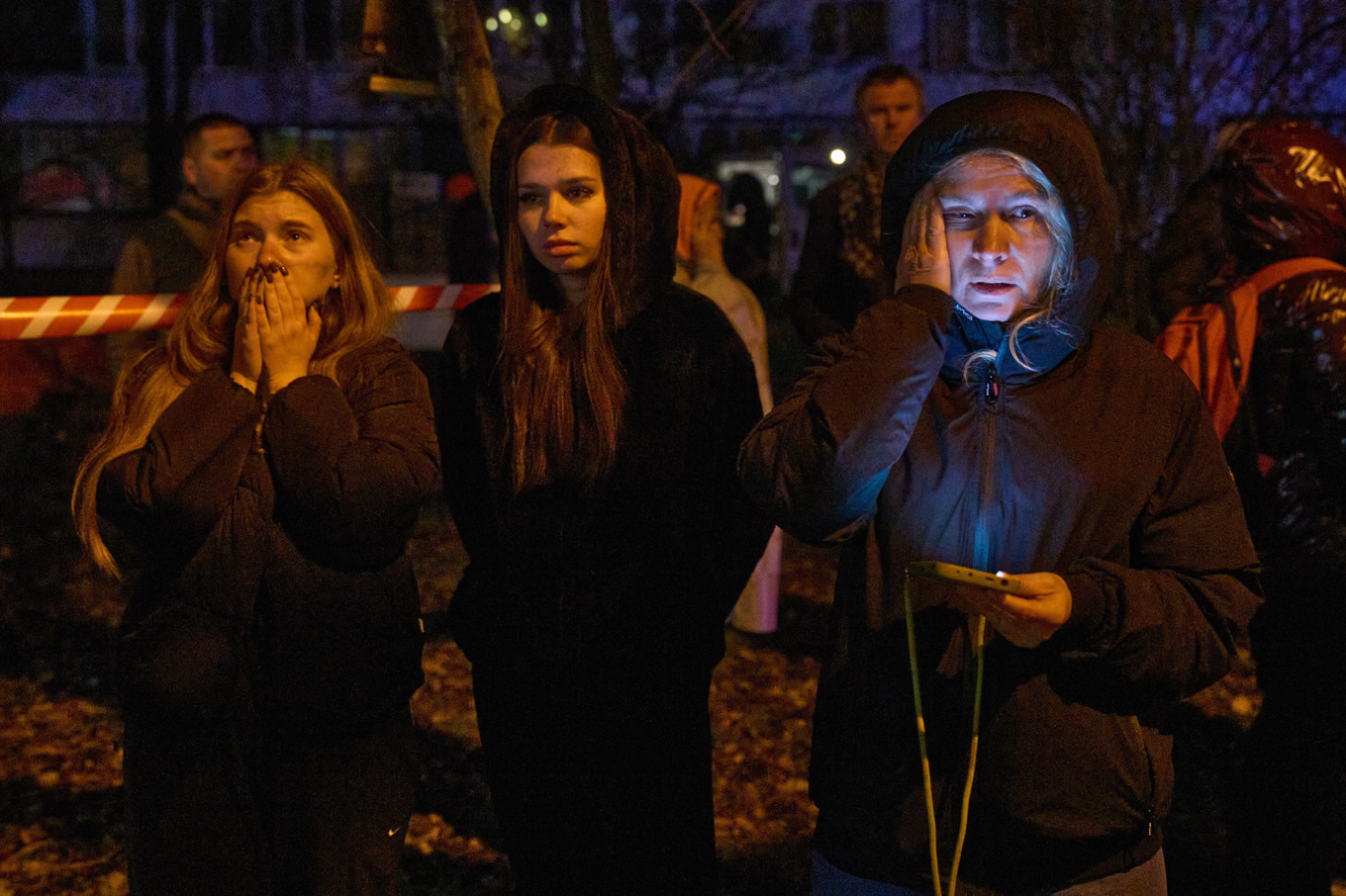 Invånare i Kiev har utrymt flerfamiljshus efter ryska attacker och följer hur brandkåren släcker bränder. Bilden togs under natten till tisdag. Foto: Efrem Lukatsky/AP/TT