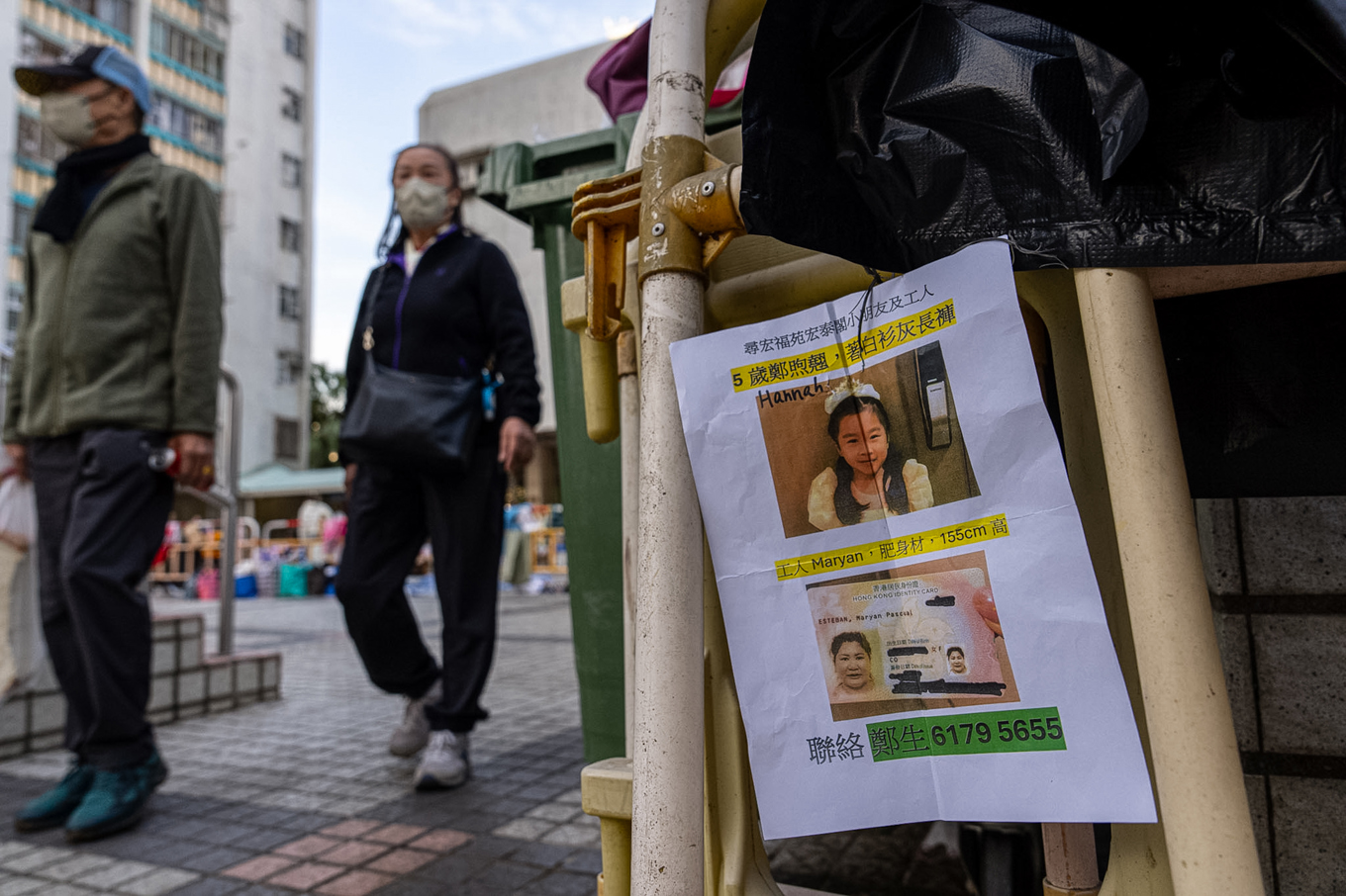 En lapp med bilder på två saknade personer har satts upp nära katastrofplatsen i Hongkong. Bild tagen på fredagen. Foto: Chan Long Hei/AP/TT